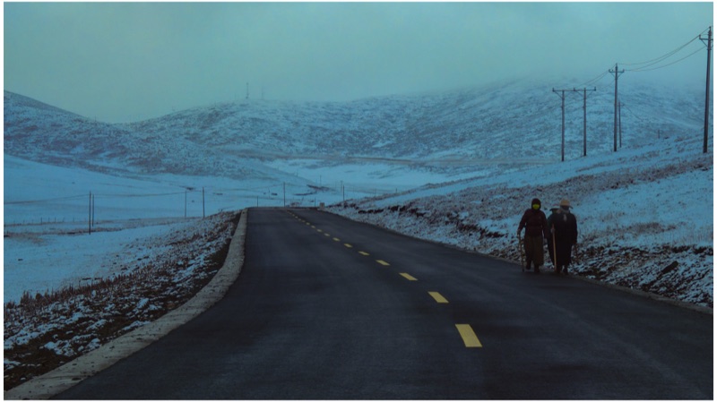 Two people walking a snowy road